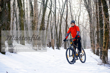 Mountain Biker Resting Bike on the Snowy Trail in the Beautiful Winter Forest