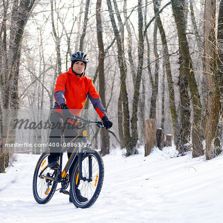 Mountain Biker Resting Bike on the Snowy Trail in the Beautiful Winter Forest