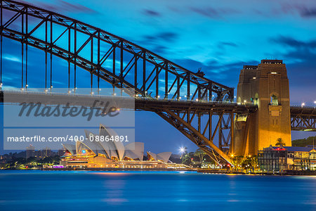 Cityscape image of Sydney, Australia with Harbour Bridge during twilight blue hour.