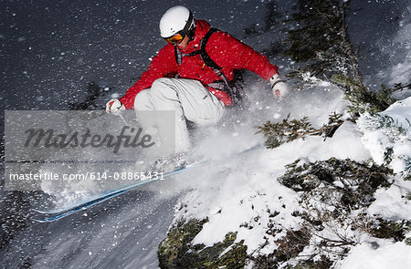 Skier jumping over small rock