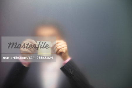 Man sticking note on frosted screen