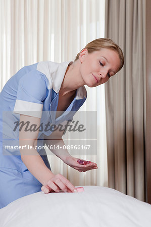 room maid placing chocolate on pillow