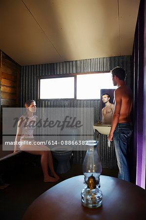 Teenage girl and young man in bathroom