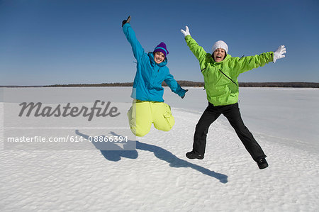 Two Women Jumping on Frozen Lake