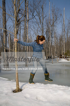 Woman Testing Ice on Pond