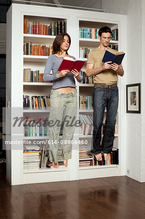 couple jumping and reading books