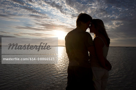 Couple kissing at sunset on the beach