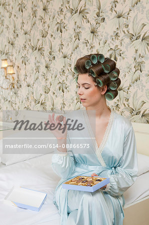 woman on bed with box of chocolates