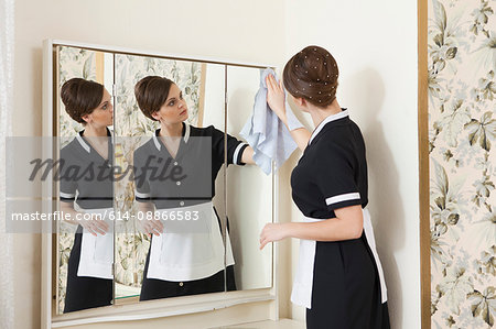 room maid cleaning mirror