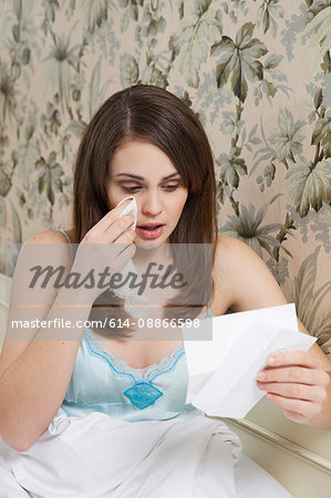 woman in bed,reading letter,crying