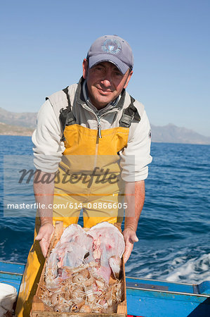 fisherman on boat, presenting the fish