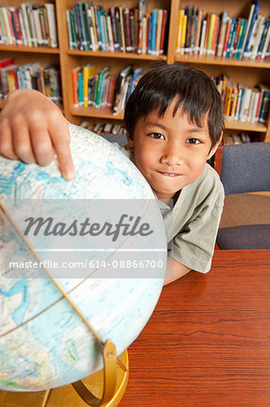 Student pointing to world globe