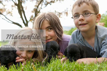 Children playing with puppies