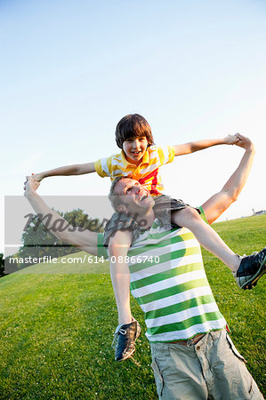 Father Carrying Son On Shoulders