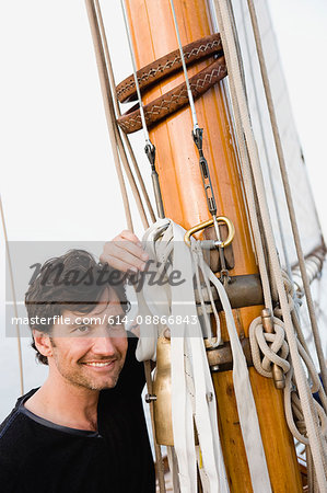 man sitting on deck of sailing boat