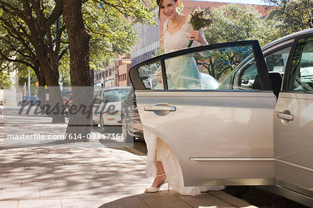 bride stepping out of car before wedding