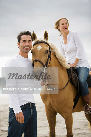 Man and woman with horse on the beach