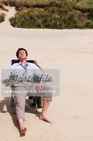 Businessman relaxing on beach Businessman relaxing on beach