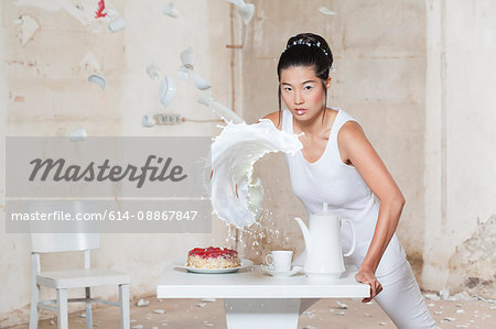 Woman pouring milk over set table