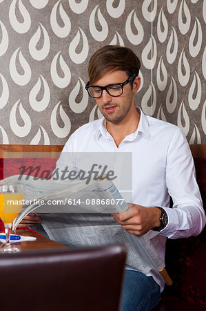 Man reading newspaper in cafe