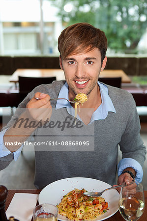 Man eating pasta in restaurant