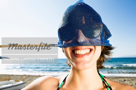 Woman holding fishing net on head