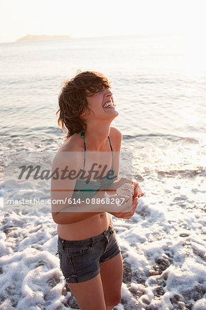 Woman holding seashells on beach