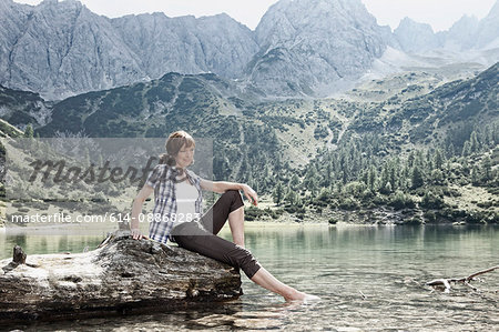 Woman dangling feet in lake