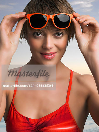 Woman putting on sunglasses outdoors