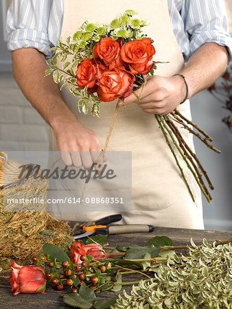 Florist tying bouquet in shop