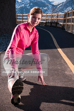 Runner stretching on rural road