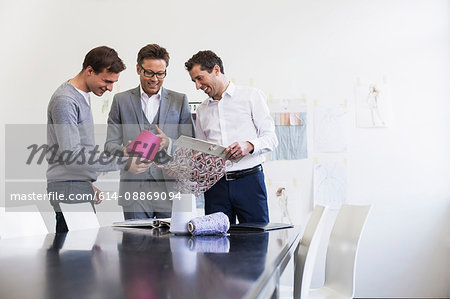 Businessmen comparing fabric swatches
