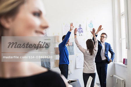 Business people high fiving in office