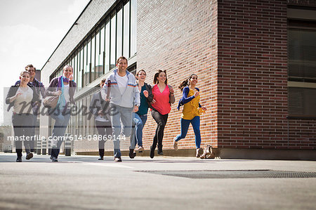 Friends running down city street