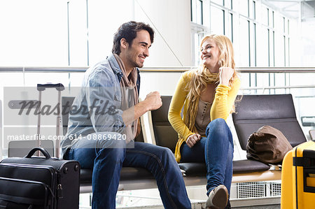 Couple talking in airport waiting area