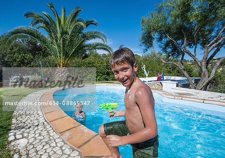Boy climbing out of outdoor pool