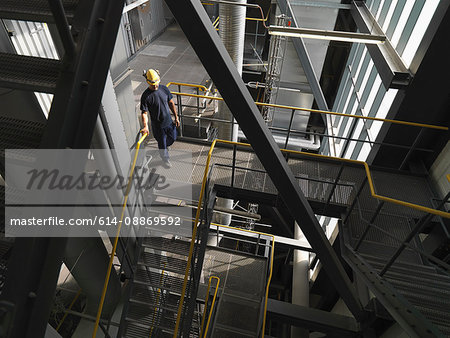 Worker climbing staircase in factory