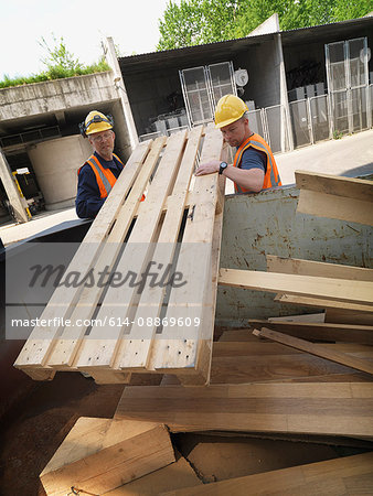 Workers hauling plywood on site