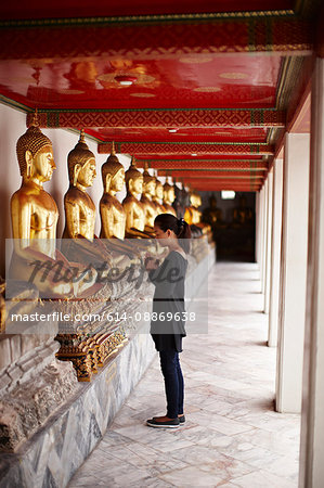 Woman praying in front of monument