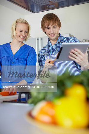 Couple cooking with tablet computer