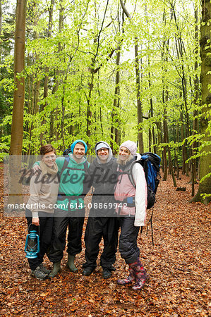 Smiling friends hiking in forest