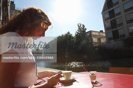 Woman in headphones having coffee