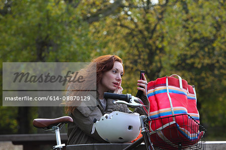 Woman applying makeup in park