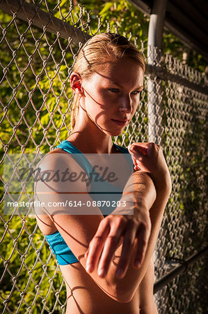 Woman stretching by fence