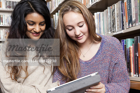 Students with tablet computer in library