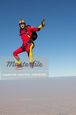 Woman skydiving over clouds