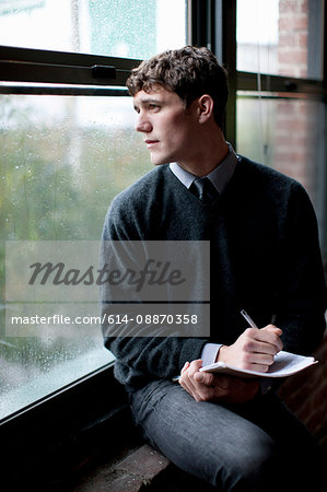 Businessman writing in windowsill