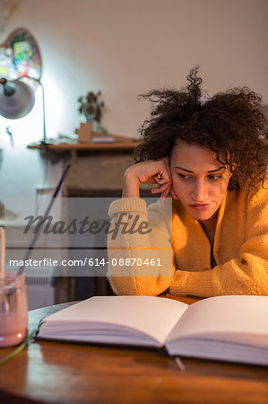 Woman reading book at desk