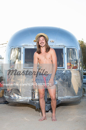 Man wearing swimsuit by trailer