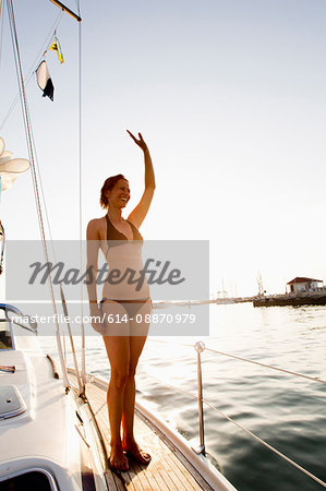 Smiling woman waving from boat